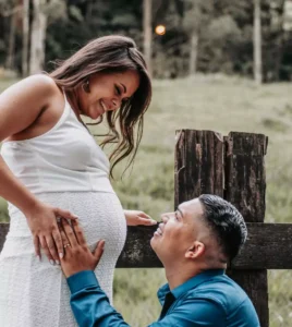 Newlywed couple holding hands with a baby bump